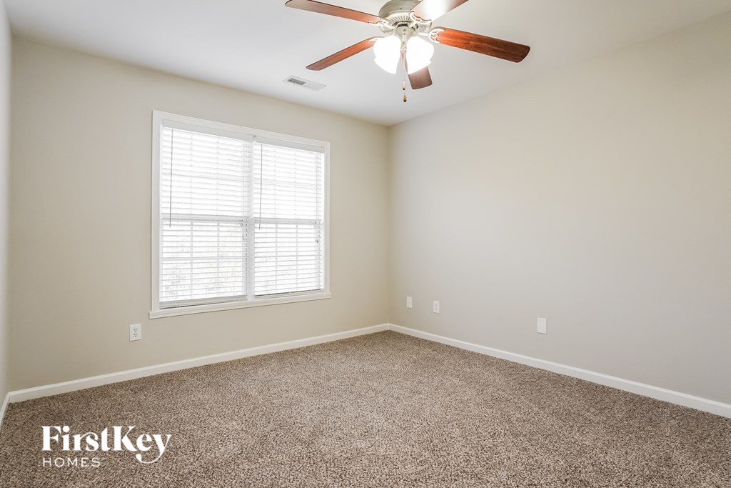 a bedroom with a ceiling fan and a window