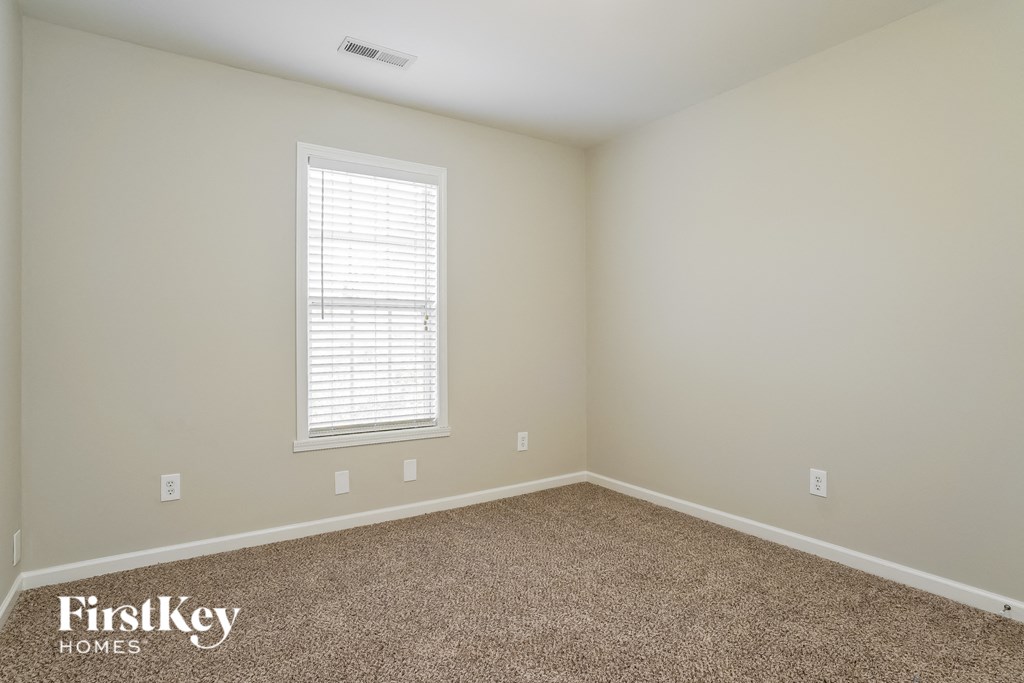 a empty room with carpet and a window