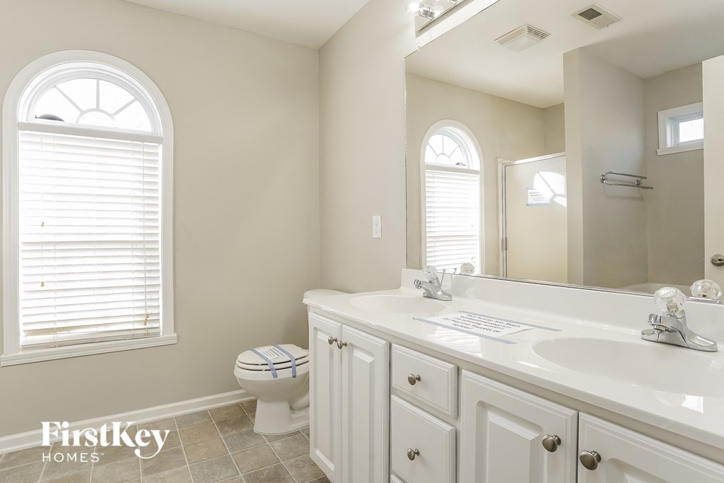 a bathroom with a large mirror and a sink and a toilet