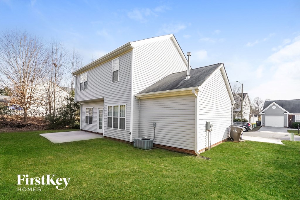 a small white house with a garage and a yard