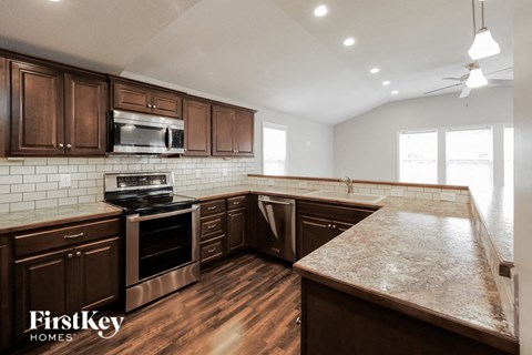 A kitchen with wooden cabinets and a granite countertop.