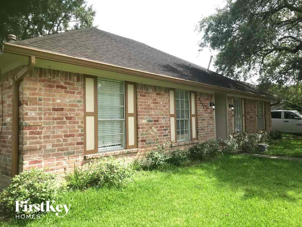 the front of a brick house with a yard and grass