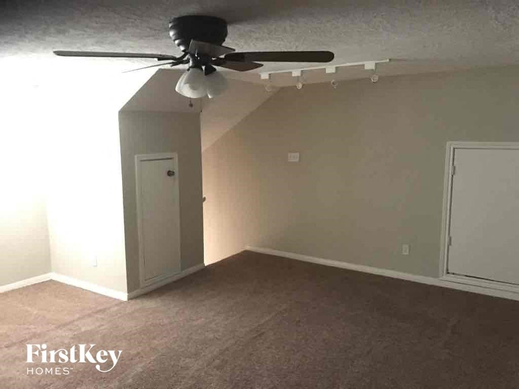 an empty room with a ceiling fan and a door