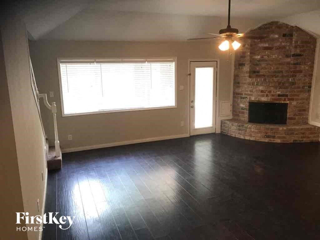 an empty living room with a fireplace and a window