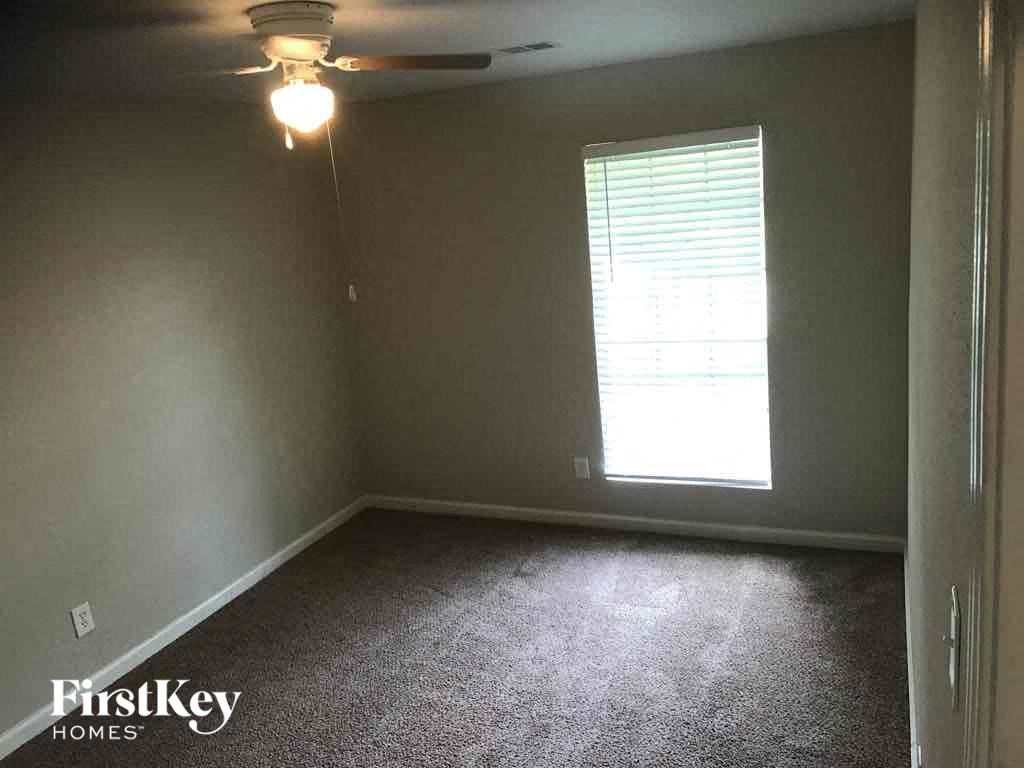 an empty room with a window and a ceiling fan