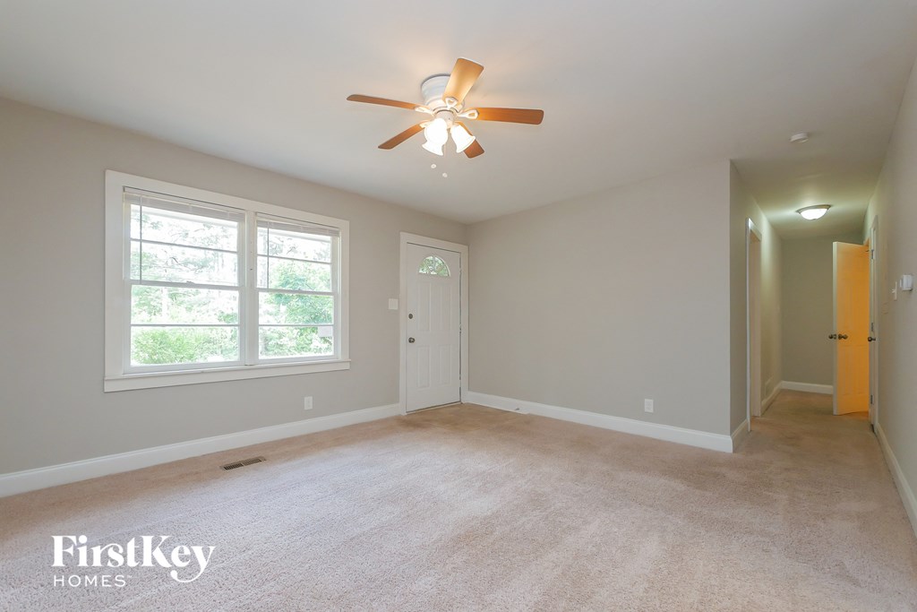 A room with a ceiling fan and a carpeted floor.
