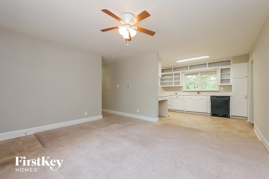 A room with a ceiling fan and a window with blinds.