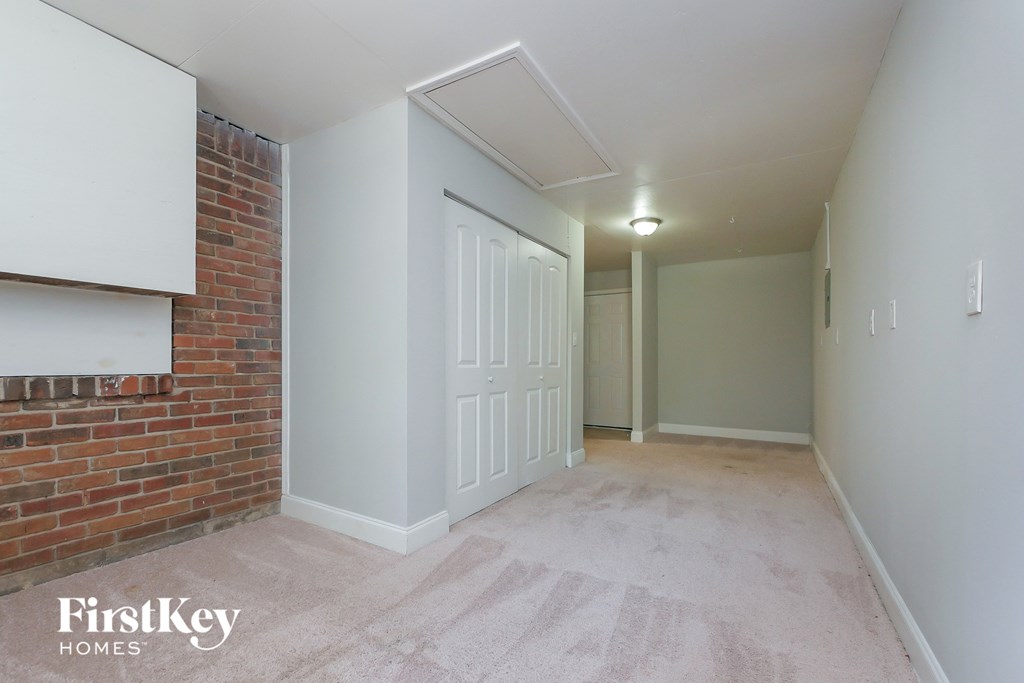 A room with a brick wall and a white door.