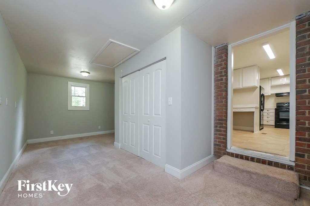 A bedroom with a white door and a window.