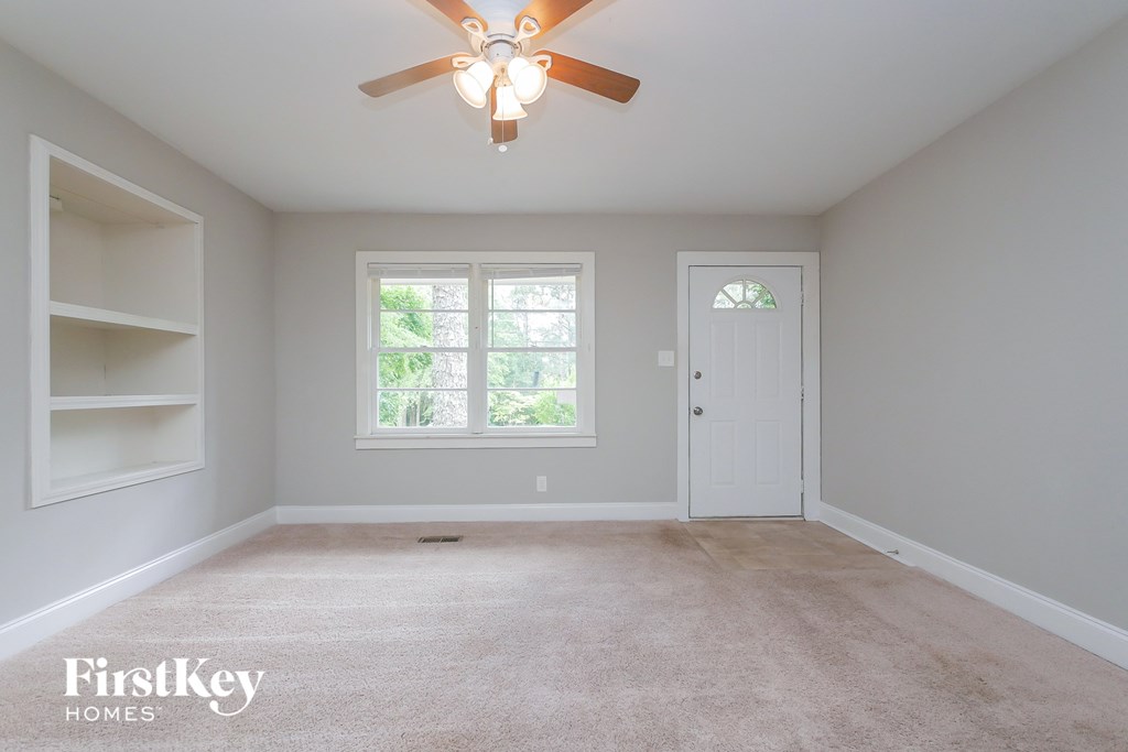 A room with a ceiling fan and a window.