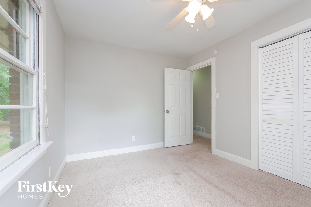 A room with a ceiling fan and a window.