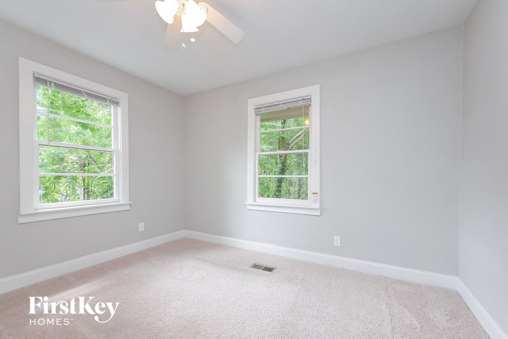 A room with two windows and a carpeted floor.