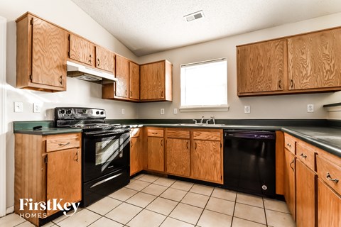 A kitchen with wooden cabinets and black appliances.