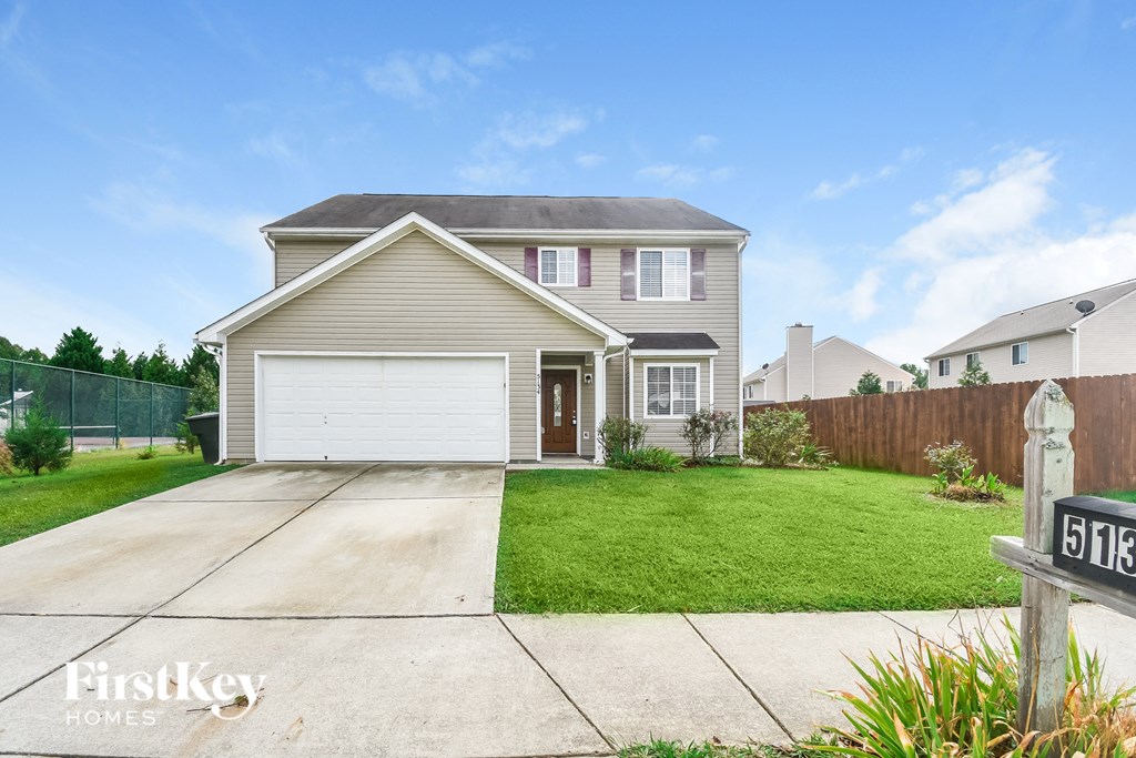 a home with a white garage door and a lawn
