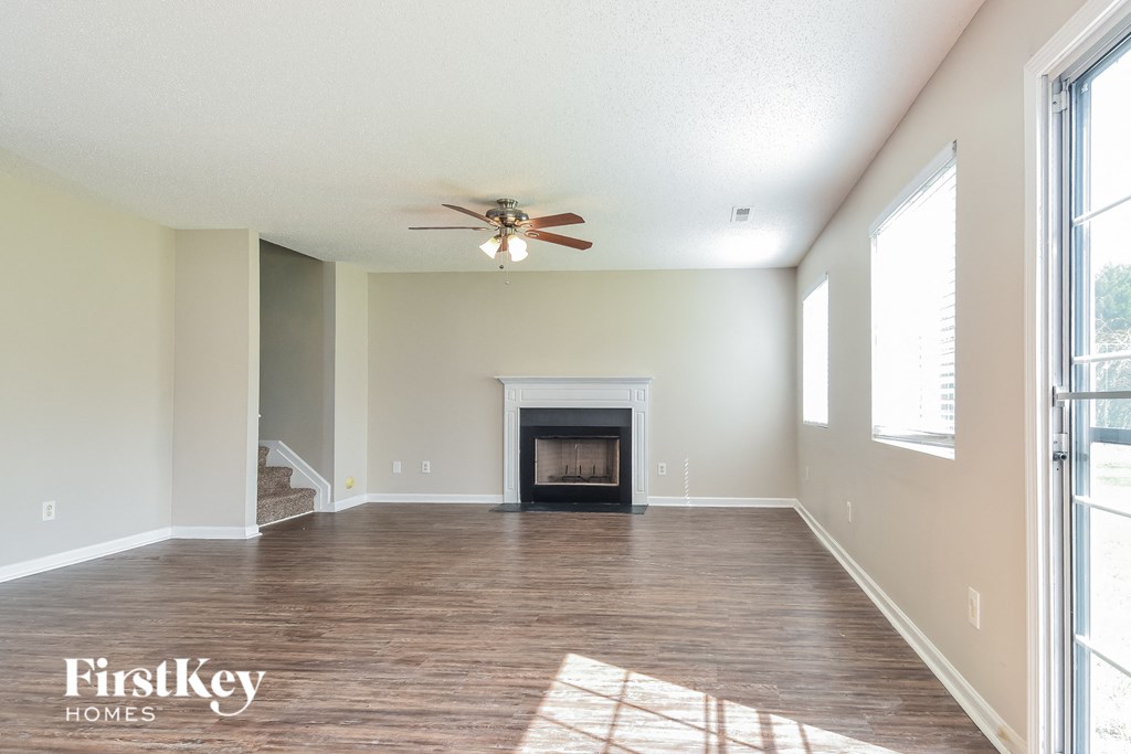 a living room with a fireplace and a ceiling fan