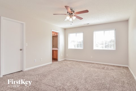 a living room with carpet and a ceiling fan