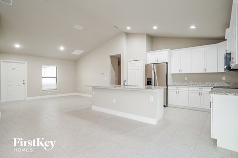 an empty kitchen with white cabinets and a white counter top