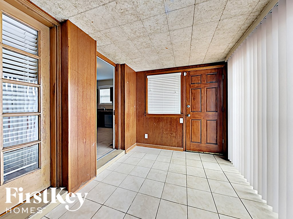 an empty hallway with wooden doors and a tile floor