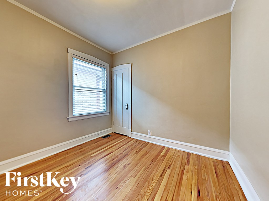 the living room of an empty house with wood floors and a window
