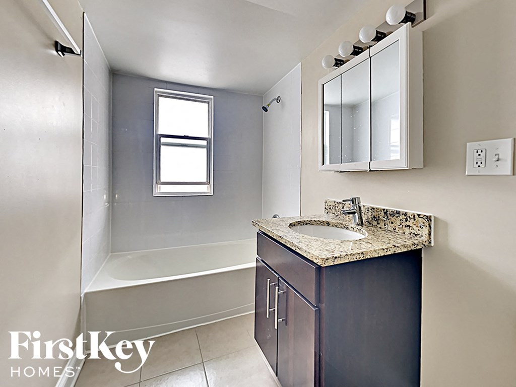 a bathroom with a sink and a shower and a mirror