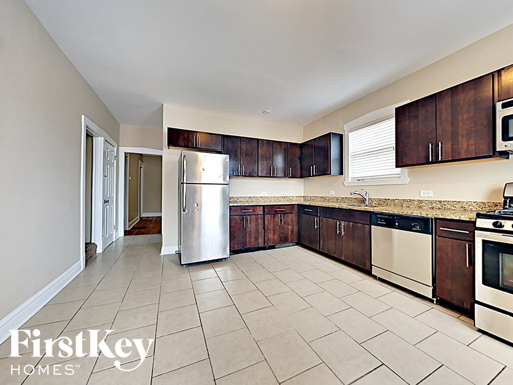 a kitchen with wooden cabinets and a stainless steel refrigerator