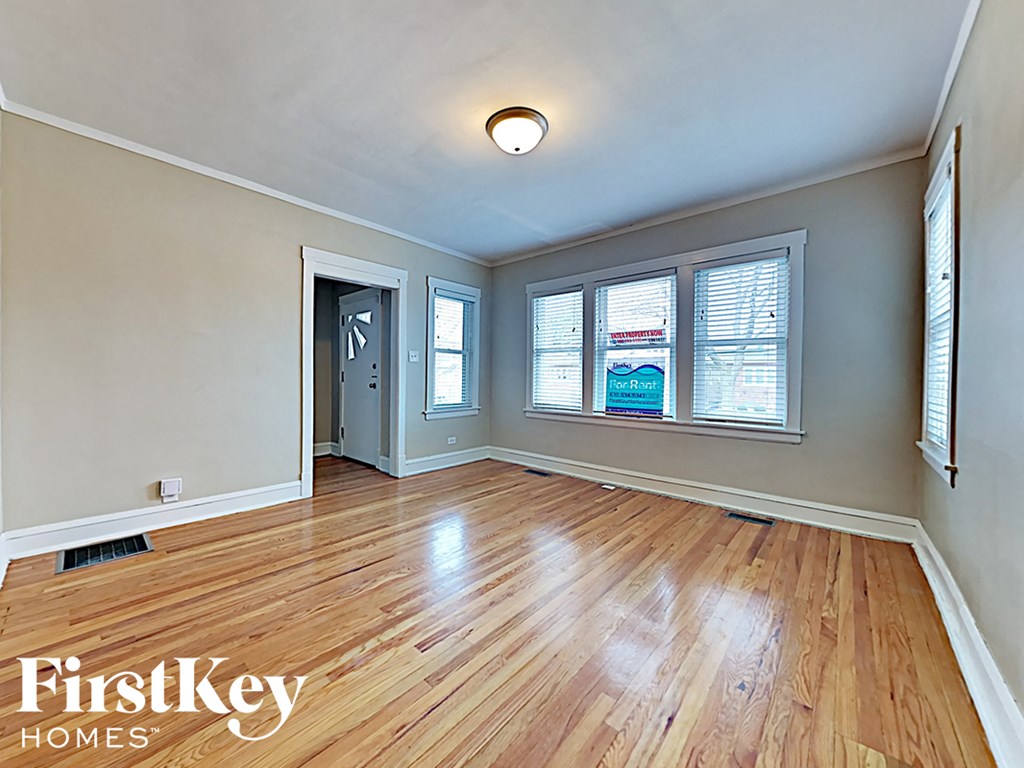 an empty living room with hardwood flooring and a window