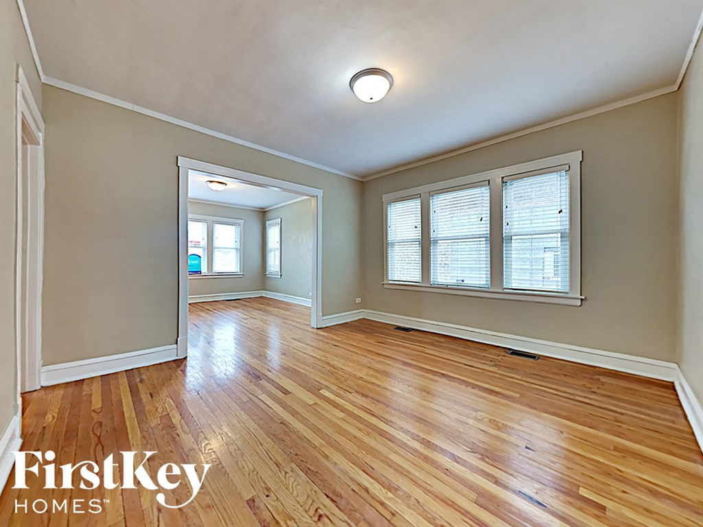 an empty living room with hardwood flooring and a window