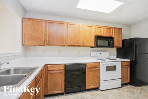 A kitchen with wooden cabinets and a stove top oven.