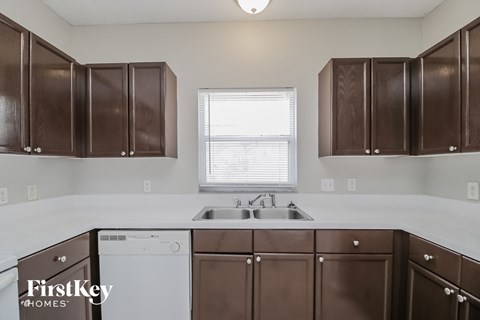 A kitchen with brown cabinets and a white dishwasher.