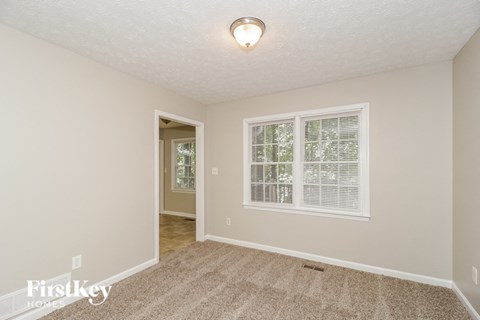a living room with a large window and a carpeted floor