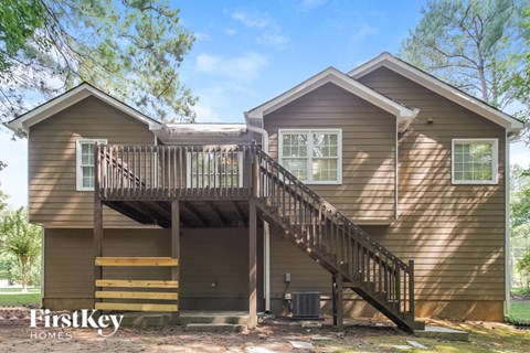 the exterior of a house with a deck and a staircase