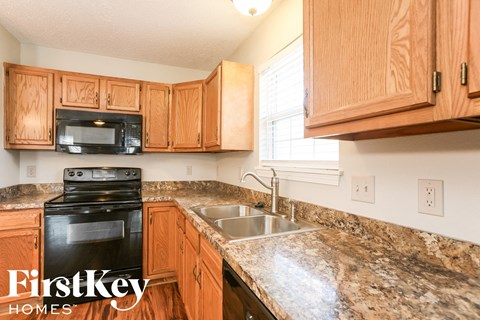 A kitchen with wooden cabinets and a granite countertop.