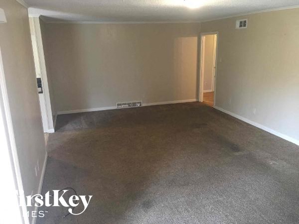 A room with a carpeted floor and two doors.