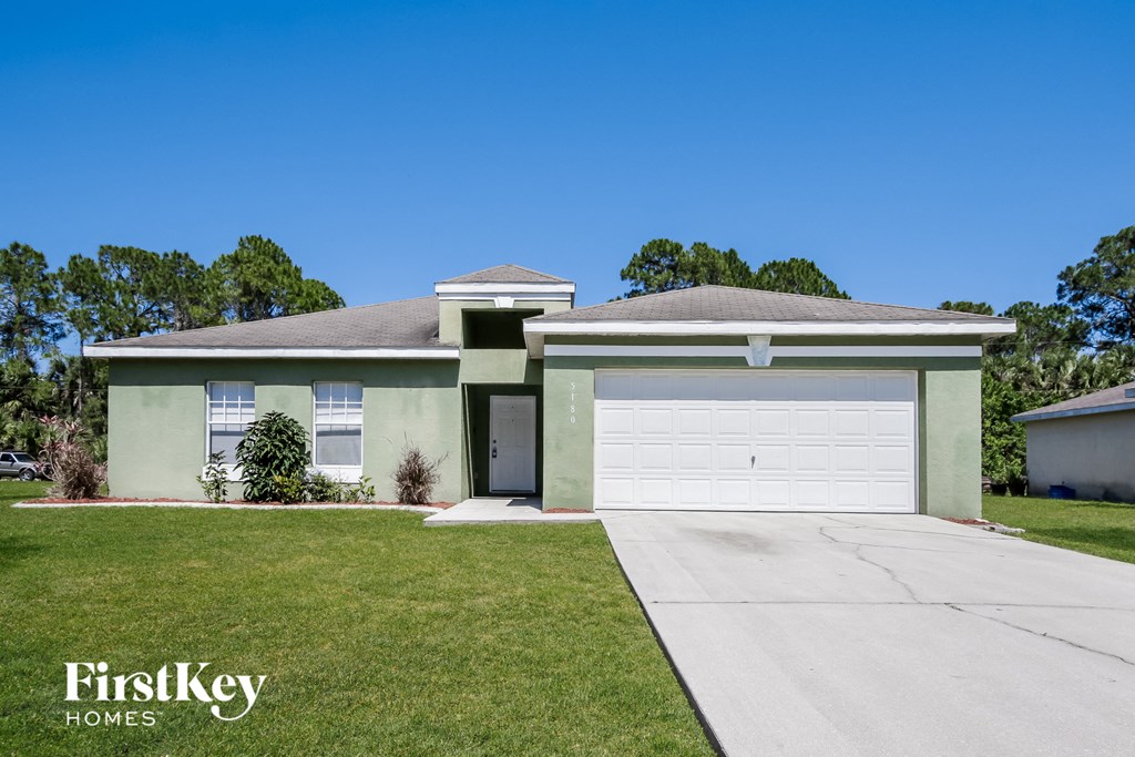 a green house with a white garage door