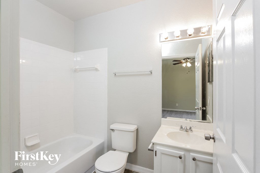 a white bathroom with a sink toilet and a mirror