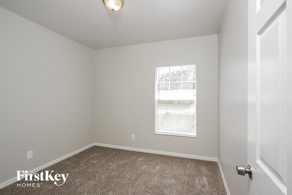 a bedroom with a carpeted floor and a window