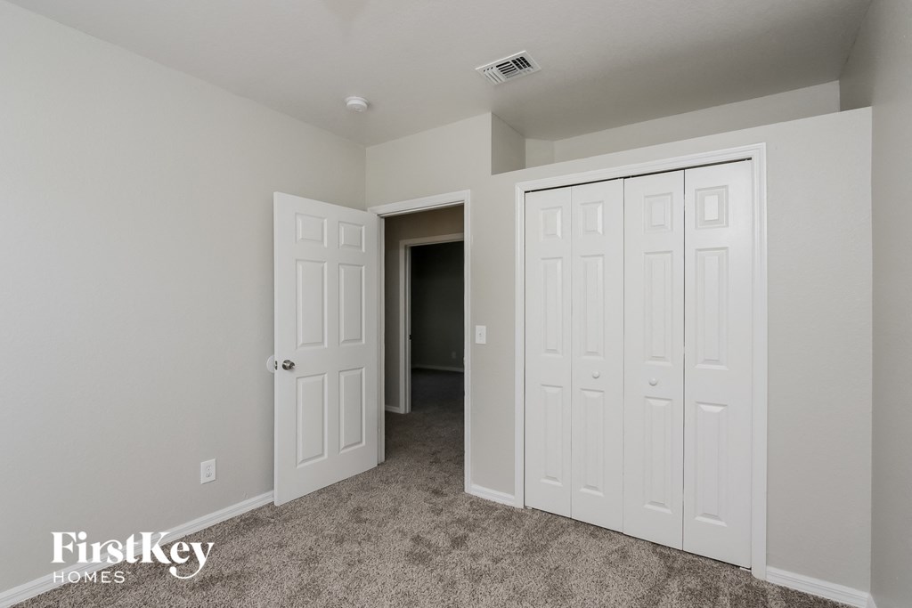 a bedroom with two closets and a door to a hallway