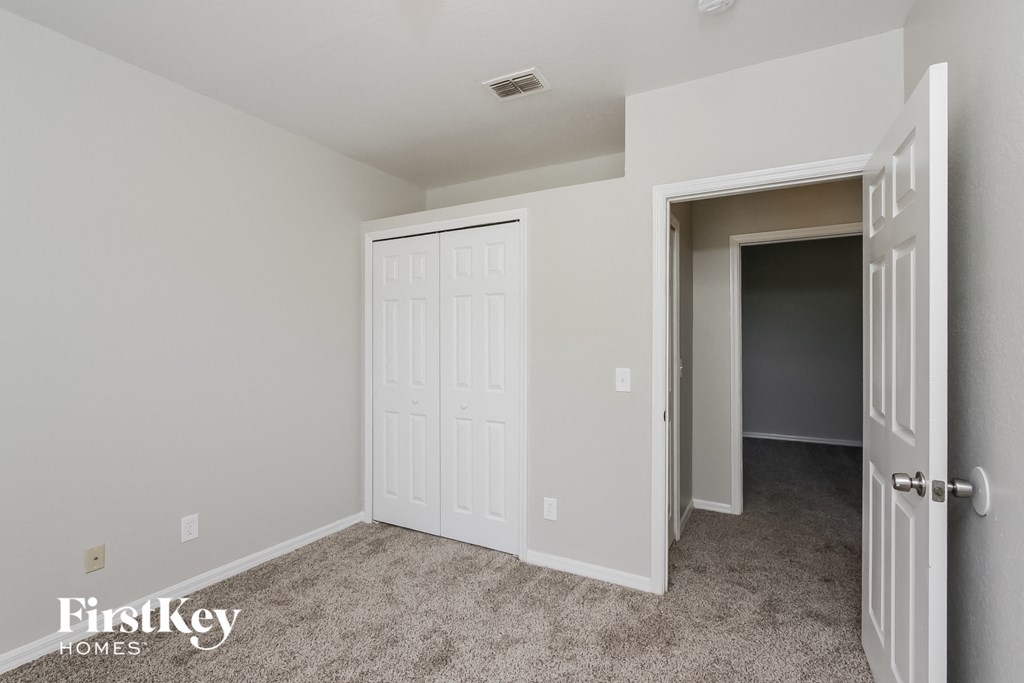 a bedroom with two closets and a door to a hallway
