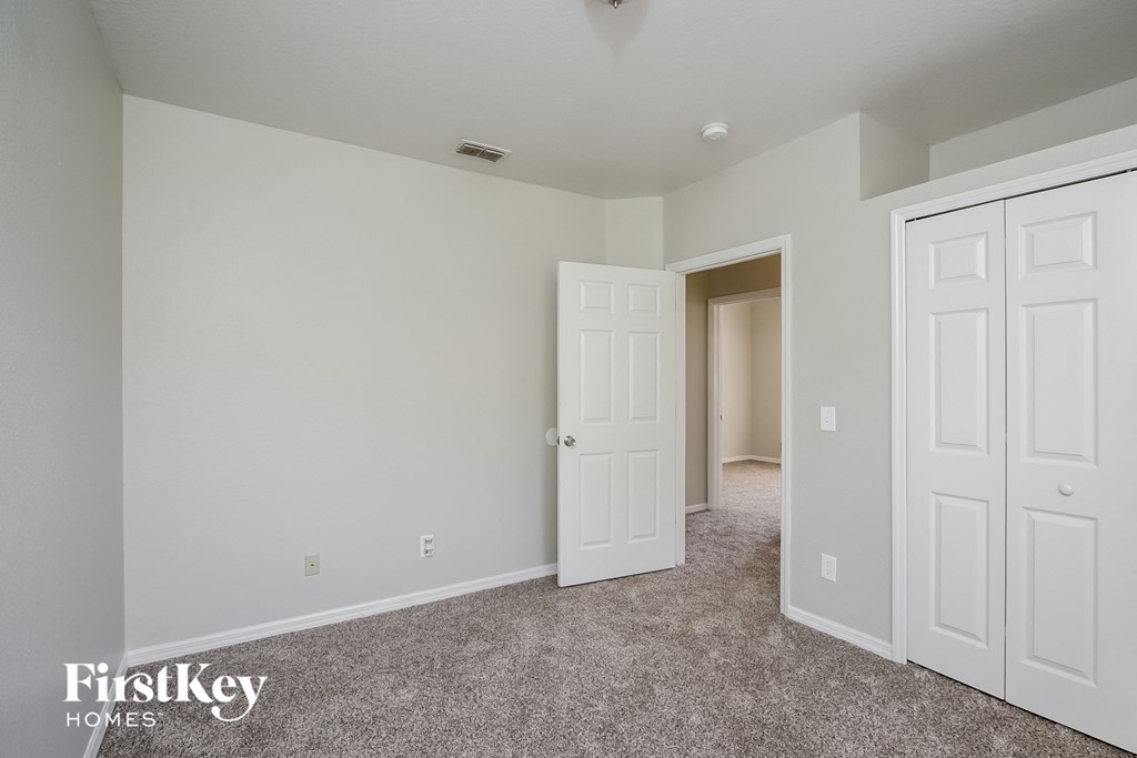 a bedroom with two closets and a door to a hallway