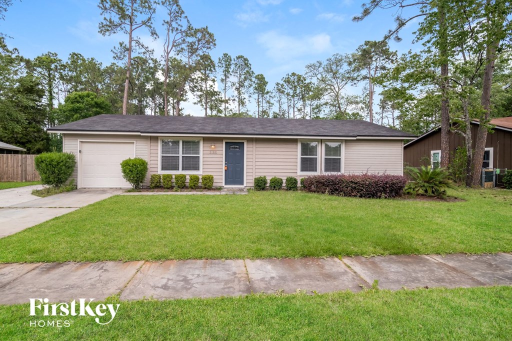 a home with a lawn and a blue door