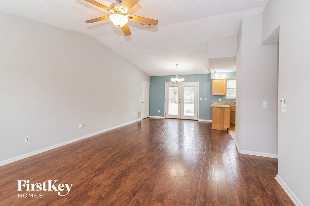 the living room and dining room with hardwood flooring and a ceiling fan
