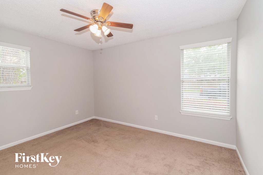 a bedroom with a ceiling fan and a window