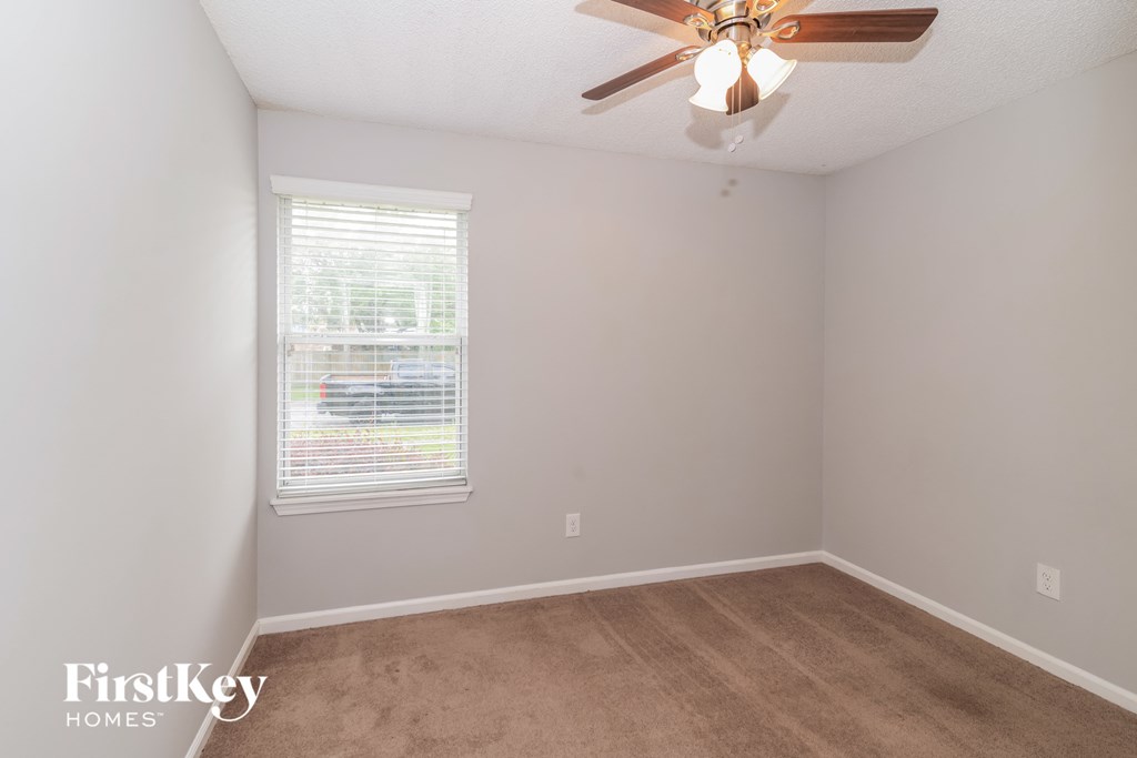 a bedroom with a ceiling fan and a window