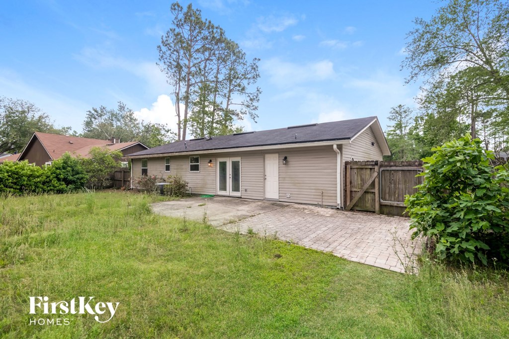 a small white house with a yard and a driveway