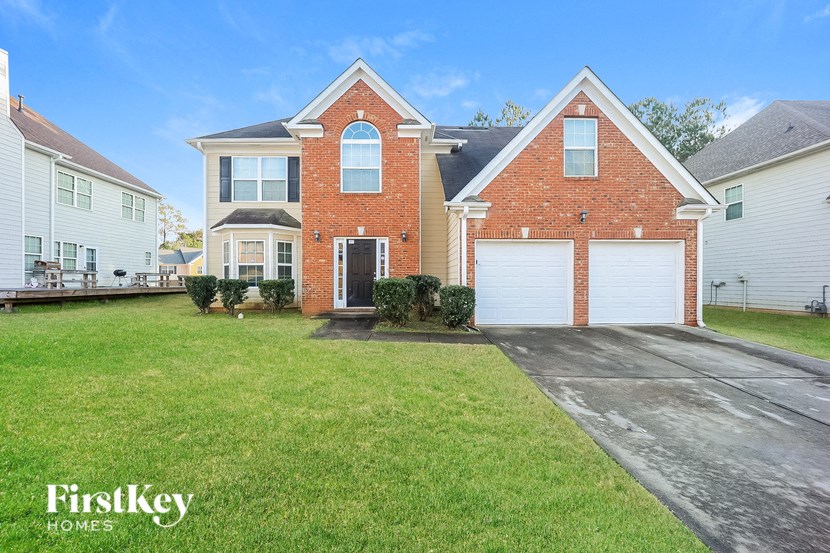 a brick house with a white garage door and a lawn