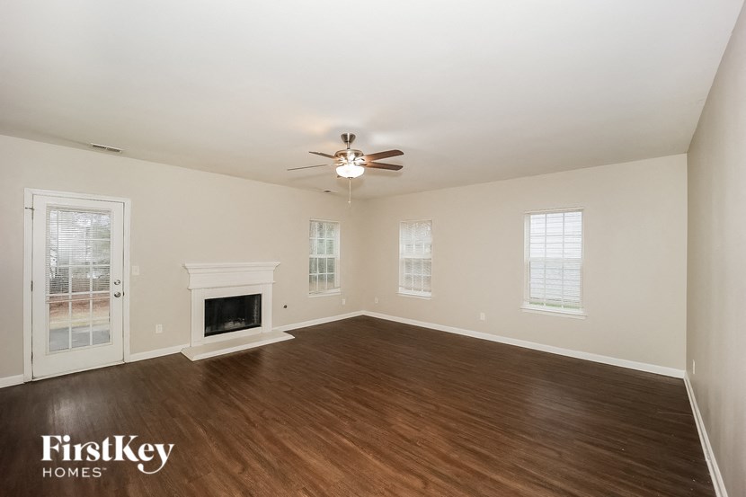 a living room with a fireplace and a ceiling fan