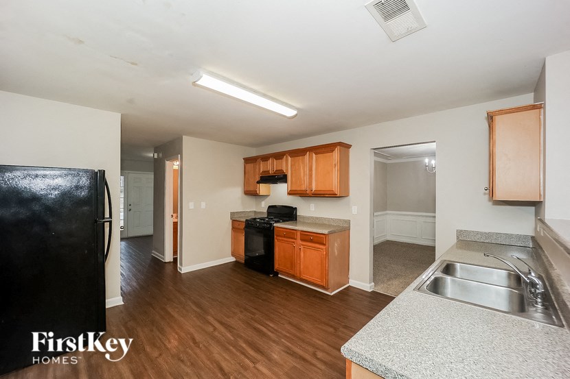 a kitchen and living room with wood flooring and white walls