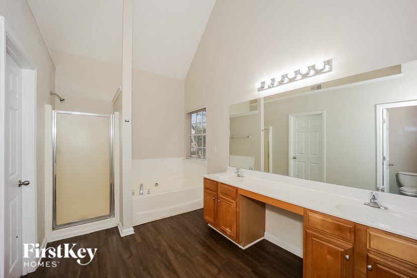 a bathroom with a large mirror and a sink and a shower