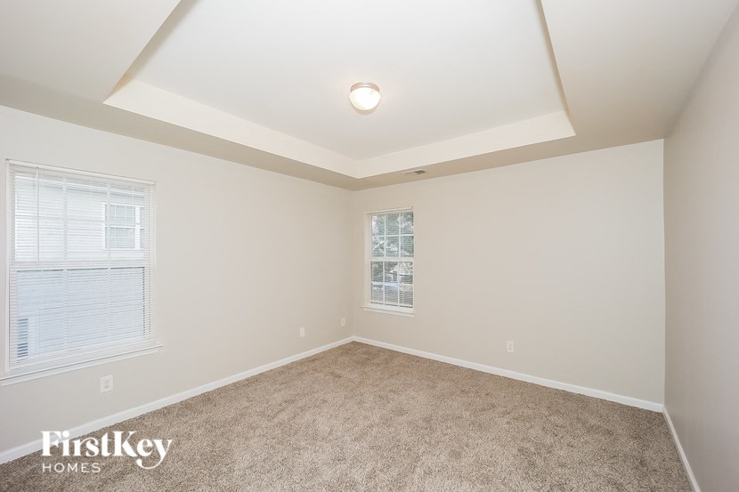 the living room of a new home with carpet and a window