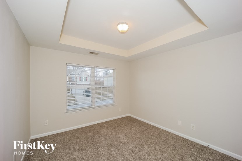 the living room of a home with carpet and a large window